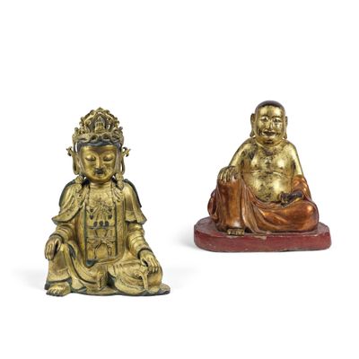 deux figurines en or représentant des bouddhas assis sur une surface blanche