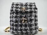 un sac à dos en tweed noir et blanc avec des finitions dorées
