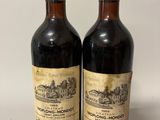 deux bouteilles de vin posées sur une table blanche