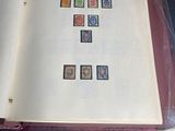an open book with stamps on it sitting on a table