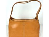 une image représentant un sac à main marron muni d'une anse, posé sur une surface blanche
