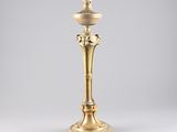 an antique brass candle holder with a bird on the top