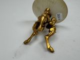 a gold figurine of a man and a woman holding an umbrella