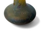 a green vase with writing on it on a white surface