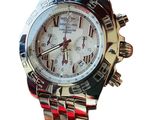 a silver and red watch with a white face