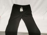 Le pantalon est noir et comporte une étiquette blanche.