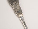 a silver spoon with a silver handle on a white surface
