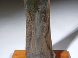 sculpture of a woman holding a knife on a wooden base