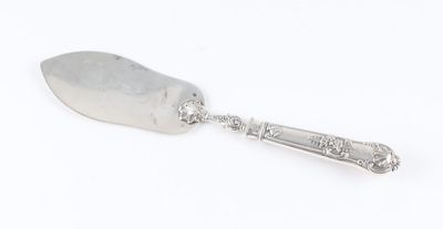 an old silver spoon with a handle on a white surface