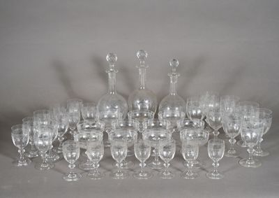 many wine glasses and decanters sitting on a table