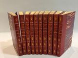 six red books lined up in a row on a white surface