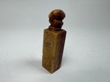 wooden sculpture of a woman with a hat on top of a wooden block