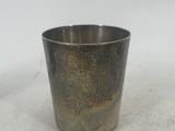 a silver cup that is sitting on a white surface