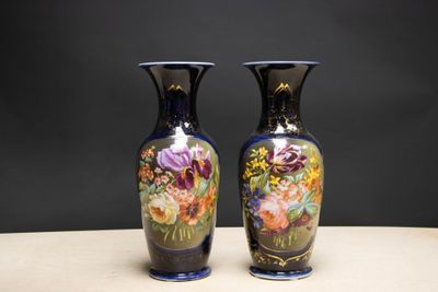 deux vases posés sur une table, sur lesquels sont peints des fleurs
