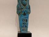 an egyptian statue of a man with a blue body on a black base