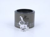 the small glass rabbit is sitting in the middle of a black container