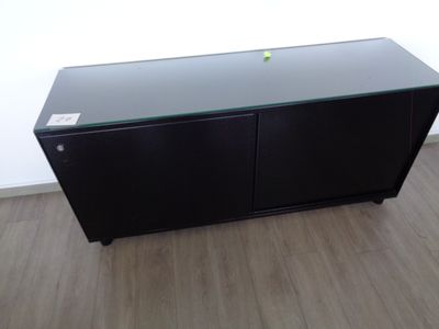 une armoire noire avec un plateau en verre et une pomme verte posée dessus