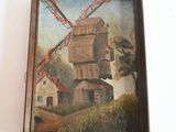 une peinture à l'huile représentant un moulin à vent, dans un cadre en bois, accrochée à un mur blanc