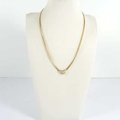 un collier à chaîne en or avec un fermoir en diamant, porté par un mannequin
