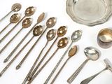 a lot of silver spoons and spoons on the table