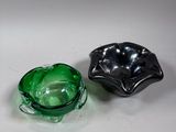 pair of green and black glass ashtrays on a white surface