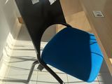 a blue chair that is sitting in front of a desk