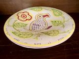 une assiette sur laquelle est peint un oiseau, posée sur une table