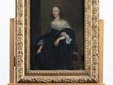 portrait d'une femme en robe noire, assise devant un chevalet en bois