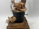 a statue of a woman sitting in a bucket with a dog
