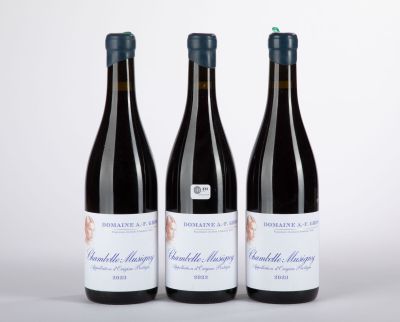 trois bouteilles de vin posées sur une table l'une à côté de l'autre