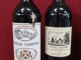 deux bouteilles de vin sont posées l'une à côté de l'autre sur une surface rouge