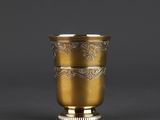a gold cup with a decorative design on the rim