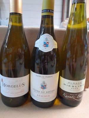 trois bouteilles de vin posées sur une table, l'une à côté de l'autre
