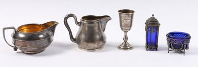 de nombreux objets en verre argenté et bleu disposés sur un fond blanc