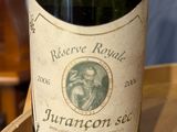 a bottle of wine sitting on top of a wooden barrel