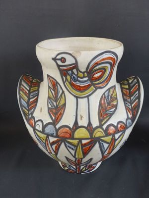 un vase blanc orné d'un oiseau sur fond noir