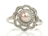 une image d'une bague en perles et diamants sur fond blanc
