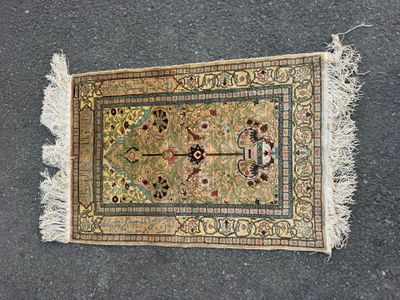 un gros plan d'un tapis posé au sol, orné de franges