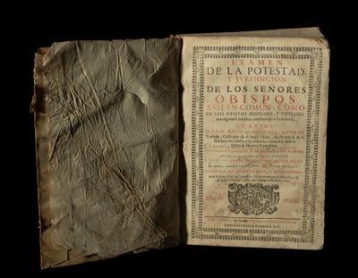 un vieux livre ouvert, dévoilant une page de texte sur fond noir