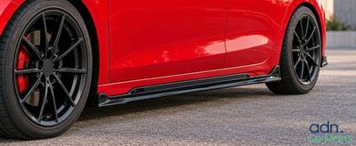 a close up of a red car parked in a parking lot