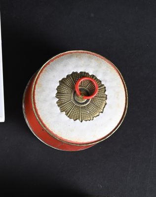 a red and white box with a red lid and a white box with a red lid and a white box with a red lid on a black table