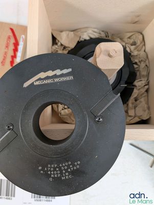 un objet noir dans une boîte en bois posée sur une table