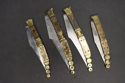 Quatre types de couteaux différents sont présentés sur une surface noire.