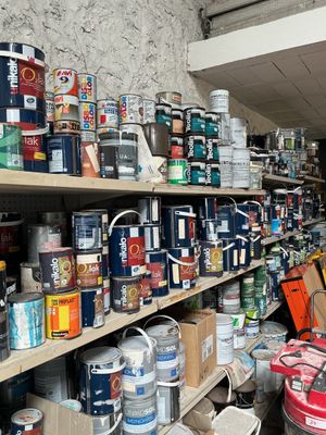 many cans of paint on the shelves in the room