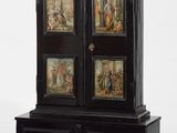 une image représentant une armoire noire sur laquelle sont posés quatre tableaux