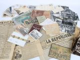 a pile of old newspapers and other papers on a table