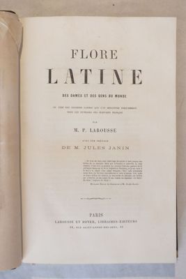un livre ouvert posé sur une table, à côté d'un rouleau de papier