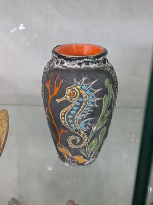 un vase orné d'un hippocampe, exposé dans une vitrine