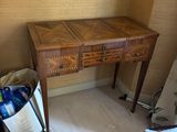 une petite table en bois sur laquelle est posé un sac, dans un coin de la pièce