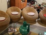 four wicker chairs and a glass table in a living room